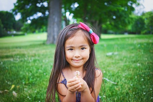 A young girl holding flower