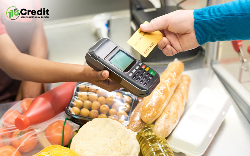 Customer paying with credit card at grocery store checkout.