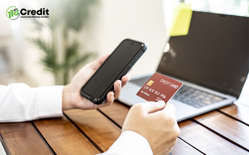 Person using phone and credit card for digital finance investment.