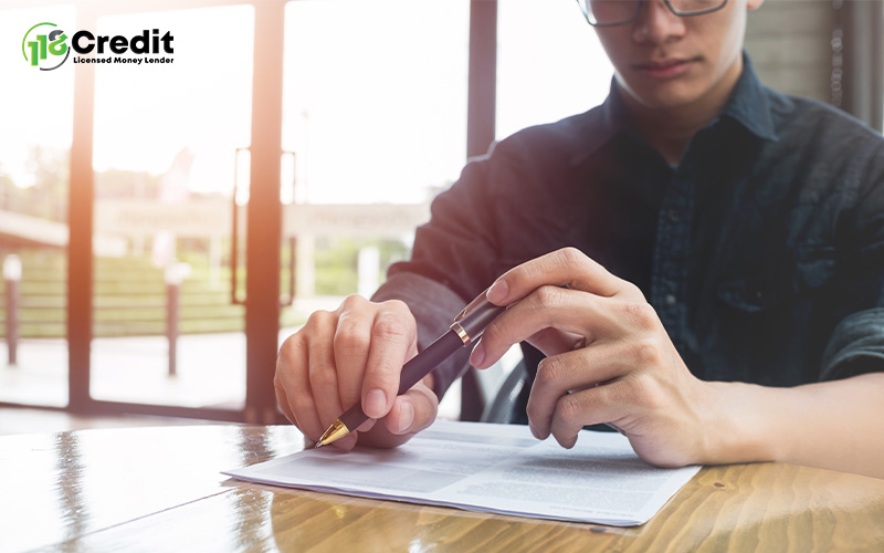 Man signing a licensed moneylender loan agreement for personal finance.