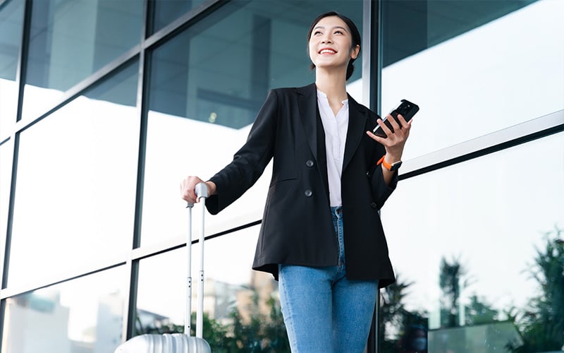 Professional woman with luggage traveling for business.