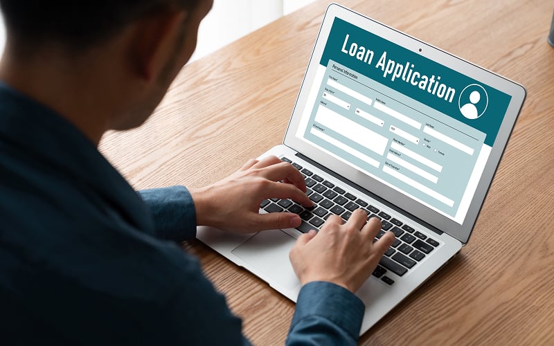 Man filling out an online personal loan application in Singapore.