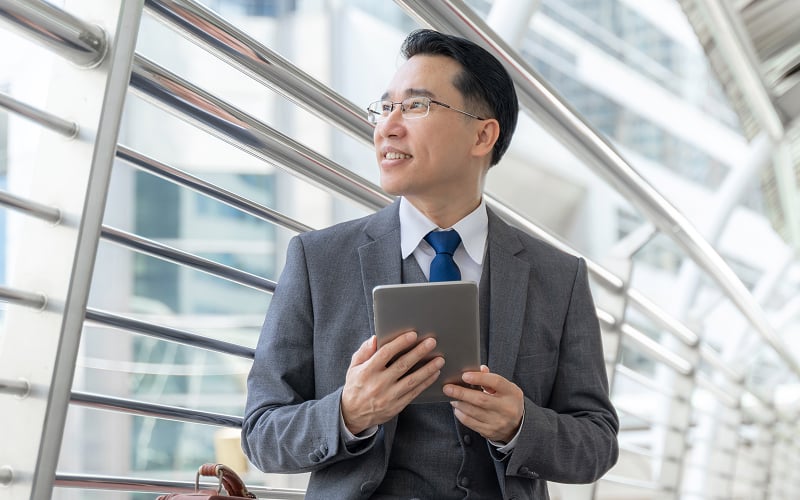 Expat businessman in Singapore holding a tablet for personal loans.